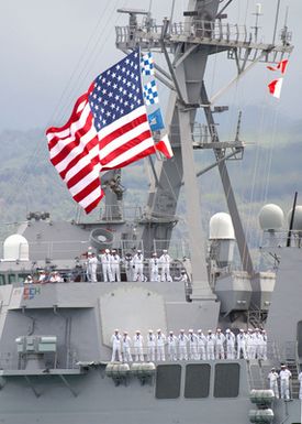 US Navy (USN) Sailors line the rails aboard the USN ARLEIGH BURKE CLASS (FLIGHT I) GUIDED MISSILE DESTROYER (AEGIS) USS PAUL HAMILTON (DDG 60), with the ships Battle ENSIGN proudly displayed as it departs Naval Station Pearl Harbor, Hawaii, for a regularly scheduled deployment to conducting missions in support of Operation ENDURING FREEDOM