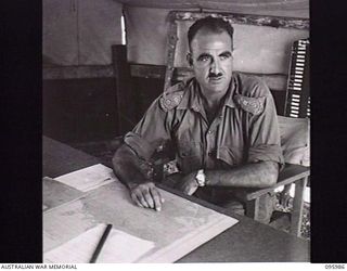 CAPE WOM, WEWAK AREA, NEW GUINEA. 1945-09-01. COLONEL N.H.W. SAXBY, ASSISTANT DIRECTOR OF MEDICAL SERVICES, HEADQUARTERS 6 DIVISION AT HIS DESK