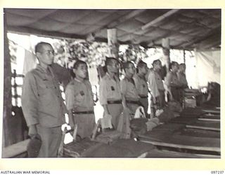 BOUGAINVILLE. 1945-09-28. A ROW OF JAPANESE STANDING BEHIND THEIR BEDS IN ONE OF THE SLEEPING HUTS. SICK AND WOUNDED PATIENTS ARE BEING CARED FOR BY JAPANESE MEDICAL OFFICIALS UNDER 7 FIELD ..