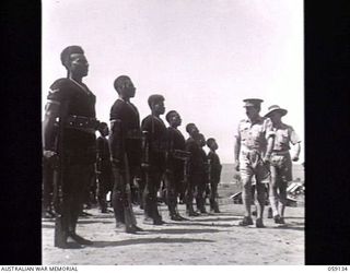 KILA, NEW GUINEA. 1943-10-24. PP1 MAJOR GENERAL B. M. MORRIS DSO, GENERAL OFFICER COMMANDING, AUSTRALIAN AND NEW GUINEA ADMINISTRATIVE UNIT (ANGAU) INSPECTING THE GUARD OF HONOUR DRAWN FROM THE ..