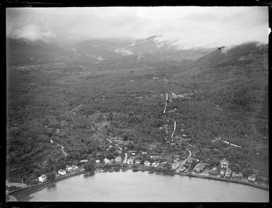 Apia Harbour coastal settlement with forest covered mountains beyond, Western Samoa