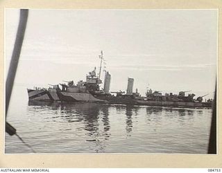 MIOS WUNDI, DUTCH NEW GUINEA. 1944-11-12. A USN DESTROYER PASSING HMAS STAWELL IN HARBOUR