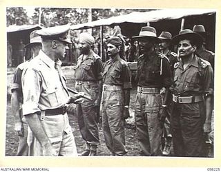 KARAVIA BAY, NEW BRITAIN. 1945-10-22. MAJOR GENERAL K.W. EATHER, GENERAL OFFICER COMMANDING 11 DIVISION, SPEAKING WITH INDIAN OFFICERS ON PARADE DURING HIS VISIT TO THE INDIAN EX-PRISONER OF WAR ..