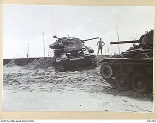 TOROKINA AREA, BOUGAINVILLE, 1945-08-06. A DISABLED M24 GENERAL CHAFFEE LIGHT TANK BEING TOWED FROM A THREE FOOT SAND BANK DURING WAR OFFICE TRIALS