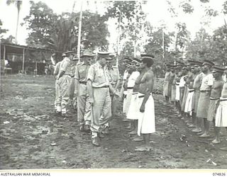 LAE, NEW GUINEA, 1944-07-22. MAJOR GENERAL B.M. MORRIS, DSO, GENERAL OFFICER COMMANDING, AUSTRALIAN NEW GUINEA ADMINISTRATIVE UNIT (1) INSPECTING NATIVE CHIEFS AND DOCTORS DURING HIS VISIT TO THE ..