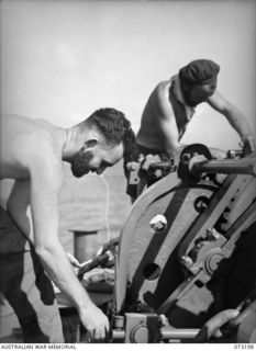 OFF MADANG, NEW GUINEA. 1944-05-14. FIRST CLASS STOKER D. HOPPY (1), WITH FIRST CLASS STOKER J.W. WALSH (2), PAINTING THE CAPSTAN ON HMAS BARCOO WHILE THE SHIP PATROLS OFF THE NEW GUINEA COAST