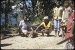 Dikai and Kuk Tsui with pig, watched by children