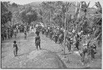 Pig festival, singsing: decorated men with eagle feather headdresses dance