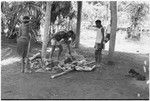 Ambaiat: distribution of pork from pig killed for damaging garden, supervised by pig's owner, Ausander (in shirt), woman awaits share