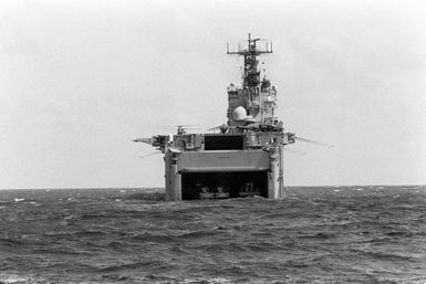 The amphibious assault ship USS SAIPAN (LHA-2) sits offshore near Vieques, Puerto Rico, during Fleet Ex 1-90, its stern gate open for landing craft operations