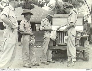 LAE, NEW GUINEA. 1944-12-30. SENIOR REPRESENTATIVE WYSHAM, AUSTRALIAN RED CROSS SOCIETY, ISSUING COMFORTS TO JAPANESE PRISONERS OF WAR AT THE MILITARY POLICE BARRACKS