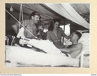 TOROKINA, BOUGAINVILLE. 1945-04-16. BOB DYER (1), AND DOLLY MAC (2), TALKING TO LIEUTENANT R.N. MCDONALD (3), DURING THE VISIT OF THE BOB DYER CONCERT PARTY TO THE 2/1 GENERAL HOSPITAL