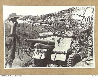 DONADABU AREA, NEW GUINEA. 1943-12-01. CREW OF NO. 1 GUN A TROOP, NO. 7 BATTERY, 2/4TH AUSTRALIAN FIELD REGIMENT CLEANING THEIR GUN DURING A LULL IN THEIR EXERCISE WITH THE 2/10TH AUSTRALIAN ..