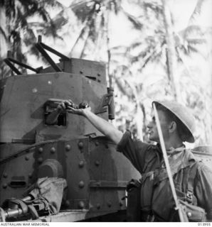 1942-12-28. PAPUA. AN AUSTRALIAN INFANTRYMAN RECEIVES GRENADES FROM A CREW MEMBER OF AN AUSTRALIAN TANK DURING THE ATTACK ON BUNA. TANKS CARRIED LARGE QUANTITIES OF GRENADES WHICH WERE SUPPLIED TO ..