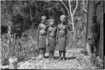 Adolescent girls (Kopi, Kanila, and Kena) smiling, ext to the Cook's house in Kwiop