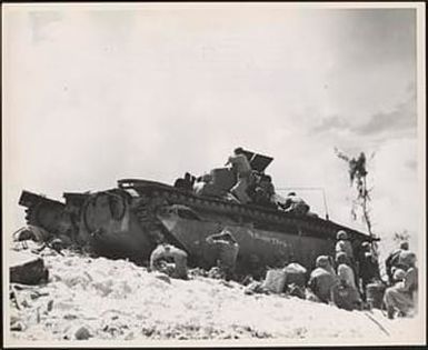 Marine infantrymen carry on the right from the shelter of an amphibious tractor which brought them ashore