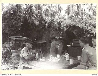 BALLALAE ISLAND, BOUGAINVILLE AREA. 1945-11-10. LIEUTENANT GENERAL V.A.H. STURDEE, GENERAL OFFICER COMMANDING FIRST ARMY (2) WHO IS TOURING THE AREA, SHOWN HAVING A CUP OF TEA ON THE BEACH WITH ..