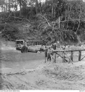 FINSCHHAFEN AREA, NEW GUINEA. 1943-11-04. TROOPS OF THE 2/3RD AUSTRALIAN FIELD COMPANY, ROYAL AUSTRALIAN ENGINEERS BUILDING A BRIDGE OVER QUOJA CREEK ON THE NEW SCARLET BEACH-SIMBANG ROAD