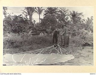 BABIANG AREA, NEW GUINEA, 1944-11-19. TROOPS OF 2/10 COMMANDO SQUADRON RECOVERING SUPPLIES DROPPED FROM A BEAUFORT BOMBER OF 100 SQUADRON, RAAF. COLOURED PARACHUTES ARE USED TO ASSIST THE LOCATION ..