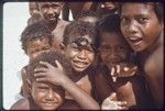 Children on the beach at Kaibola (close-up), boy in center wears swim goggles