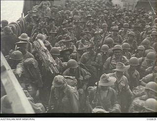 MOMOTE, LOS NEGROS ISLAND, ADMIRALTY ISLANDS. 1944-03-18. RAAF REINFORCEMENTS, TOGETHER WITH AMERICAN TROOPS, WAITING TO GO ASHORE ON LOS NEGROS ISLAND FROM A LANDING CRAFT TANK