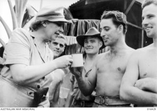 New Guinea. 1944. Private M. Daly of Bendigo, Vic, offers Miss Strella Wilson a mug of Army tea after her arrival in New Guinea to entertain the troops