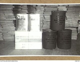 KENSINGTON, VIC. 1943-10-23. FLOUR PACKED INTO TWO TYPES OF CONTAINERS BY MESSRS. KIMPTON & SONS FOR DESPATCH TO THE TROOPS IN NEW GUINEA. A CASE CONTAINS TWO TINS, GROSS WEIGHT 66LBS, 25LB OF ..