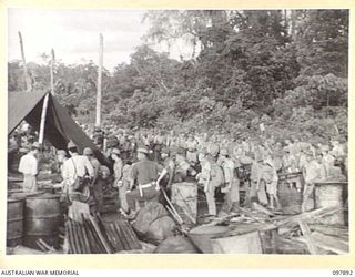 KAHILI, BOUGAINVILLE. 1945-09-30. JAPANESE TROOPS LINED UP TO RECEIVE NUMBERED IDENTITY DISCS BEFORE BEING MOVED TO THE CONCENTRATION AREA ON FAURO ISLAND. JAPANESE OFFICERS CHECKED THE ROLLS AND ..