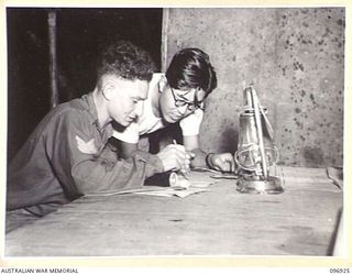 KAHILI, BOUGAINVILLE. 1945-09-10. SERGEANT S. CRAWCOUR A MEMBER OF THE BUIN LIAISON PARTY FROM HEADQUARTERS 2 CORPS, AND LIEUTENANT MASAHARU HORIGUCHI, A JAPANESE NAVAL MEDICAL OFFICER, TRANSLATING ..