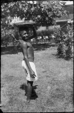 Man with a tray of flowers on his head, Rabaul, New Guinea, ca. 1929 / Sarah Chinnery