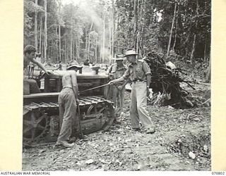 WAU - LAE ROAD, NEW GUINEA, 1944-03-03. VX18592 LANCE-CORPORAL J. CHILDS ( ), PICTURED WITH LANCE-CORPORAL H. HORN, FORMERLY A CHIEF TESTER AND ENGINEER WITH THE BULOLO GOLD DREGING COMPANY ( ), ON ..