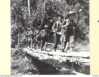 FARIA RIVER, NEW GUINEA, 1944-02-15. MEMBERS OF "A" COMPANY OF THE 57TH/60TH INFANTRY BATTALION CROSSING A BRIDGE IN THEIR MARCH UP THE FARIA RIVER TO RELIEVE THE 2/9TH INFANTRY BATTALION AT THE ..