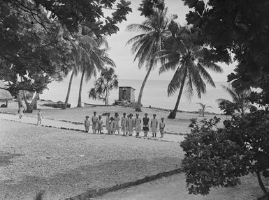 [A group of Polynesian children standing on a coastal pathway]