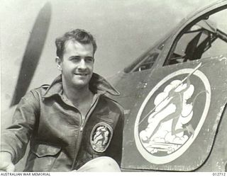 PORT MORESBY. LIEUTENANT JOHN HALL OF ALABAMA, A PILOT OF THE UNITED STATES ARMY AIR CORPS AIRACOBRA 40TH PURSUIT SQUADRON. HE IS DISPLAYING THE SQUADRON'S DEVIL EMBLEM ON HIS TUNIC AND ON THE ..