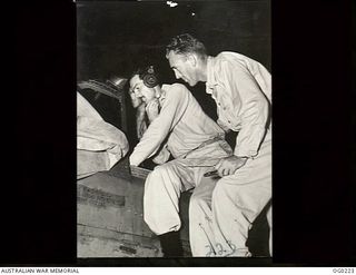 VIVIGANI, GOODENOUGH ISLAND, PAPUA. 1943-11-04. WIRELESS MECHANICS CHECKING A RAAF KITTYHAWK AIRCRAFT AT NIGHT BEFORE A DAWN ATTACK ON JAPANESE POSITIONS IN NEW BRITAIN. LEFT TO RIGHT: LEADING ..