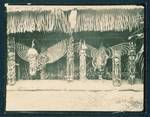 Carvings leaned against thatched building at a sing-sing, Kavieng, New Ireland, New Guinea, Jun 1930