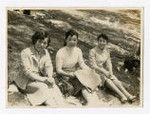 Three women sitting on the grass