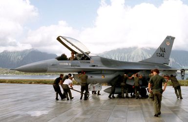 Maintenance crew members push an F-16 Fighting Falcon aircraft into a parking position during exercise COPE ELITE '81. The aircraft is from the 428th Tactical Fighter Squadron, 474th Tactical Fighter Wing