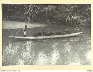 MILNE BAY, NEW GUINEA. 1944-04-20. NATIVES POLING A CANOE LOADED WITH SAC-SAC (SAGO PALM) ROOFING MATERIAL AT THE BARAGA NATIVE LABOUR CAMP, AUSTRALIAN NEW GUINEA ADMINISTRATIVE UNIT