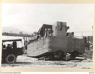 PURUATA ISLAND, SOUTH BOUGAINVILLE. 1945-05-29. A LANDING CRAFT MECHANIZED OF 42 LANDING CRAFT COMPANY, WHICH HAS BEEN DRAWN ONTO A BEACH BY TRACTOR FOR THE REPAIR OF UNDERWATER GEAR