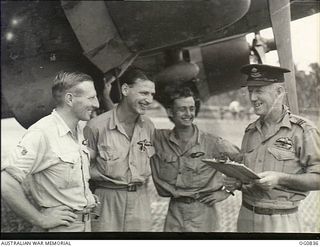 NEW GUINEA. C. 1944. RAAF AIRCREW STANDING IN FRONT OF A DOUGLAS TRANSPORT AIRCRAFT. LEFT TO RIGHT: FLIGHT SERGEANT (FL SGT) DAVIES; FL SGT HARTLEY; FL SGT G. K. HALL; FLIGHT LIEUTENANT MCGINNIS