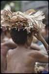 Mortuary ceremony: woman carries banana leaf bundle on her head