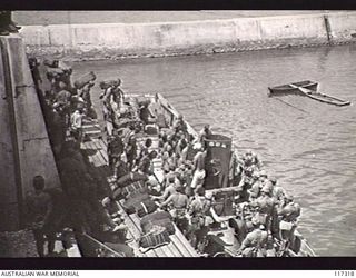 NAURU ISLAND. 1945-09-16. JAPANESE POWS BOARDING A BARGE WHICH IS TO TAKE THEM OUT TO THE RAN VESSEL WHICH IS TO EVACUATE THEM TO BOUGAINVILLE SOON AFTER THE ISLAND WAS OCCUPIED BY TROOPS OF THE ..