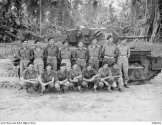 Group portrait of personnel of Fighting Headquarters Troop, B Squadron, 2/4th Armoured Regiment. Left to right, back row: VX109541 Trooper (Tpr) J E Logan of Footscray, Vic; SX13264 Corporal (Cpl) ..