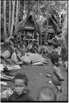 Mortuary ceremony, Omarakana: ritual exchange takes place in front of mourning houses, piles of banana leaf bundles and fiber skirts are covered