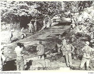 1943-09-29. NEW GUINEA. ATTACK ON FINSCHHAFEN. AT THE DISEMBARKATION POINT AMERICAN ENGINEERS SWING A BULLDOZER INTO ACTION TO BUILD A ROAD FROM THE BEACH TO ENABLE SUPPLIES TO BE BROUGHT FORWARD. ..