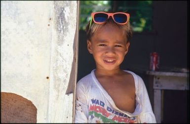 Child wearing pink framed sunglasses