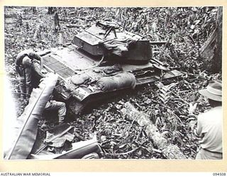 TOROKINA, BOUGAINVILLE, 1945-07-03. AN M24 GENERAL CHAFFEE LIGHT TANK BOGGED DOWN ON ITS RIGHT SIDE DURING TRIALS CONDUCTED FOR THE WAR OFFICE