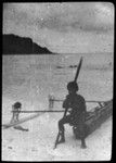 Man holding paddle, and sitting on canoe