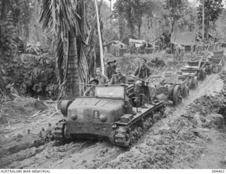 SOUTH BOUGAINVILLE. 1945-07-29. A JAPANESE PRIME MOVER WHICH HAD BEEN USED FOR TOWING ARTILLERY IS NOW PUT TO GOOD USE BY 29 INFANTRY BRIGADE TOWING JEEP TRAILERS LOADED WITH SUPPLIES FOR FORWARD ..